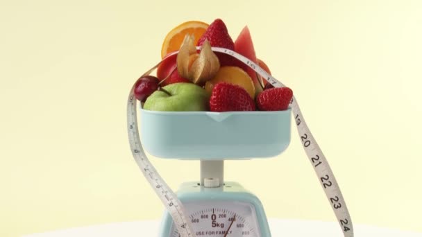 Fruits and tape measure on kitchen scales — Stock Video