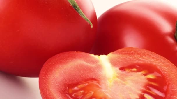 Medio tomate delante de tomates enteros — Vídeos de Stock