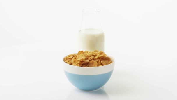 Un tazón de copos de maíz y una botella de leche — Vídeo de stock