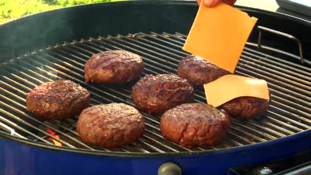 Putting cheese on burgers — Stock Video