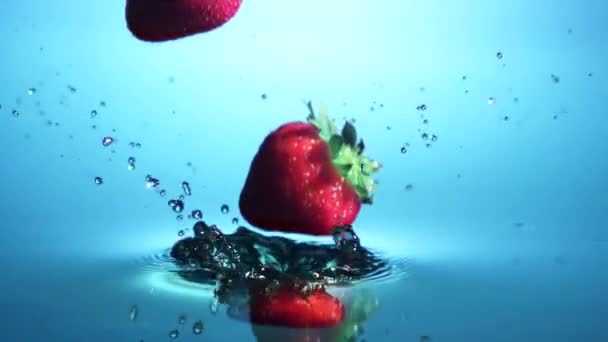 Jordgubbar som faller i vatten — Stockvideo