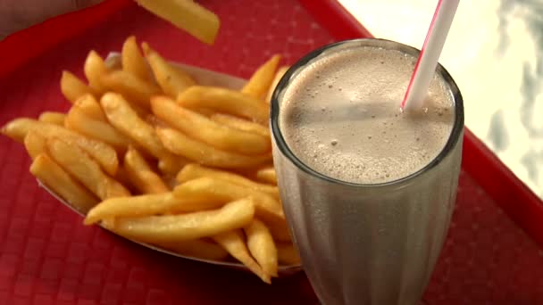 Vrouw dompelen chips in milkshake — Stockvideo