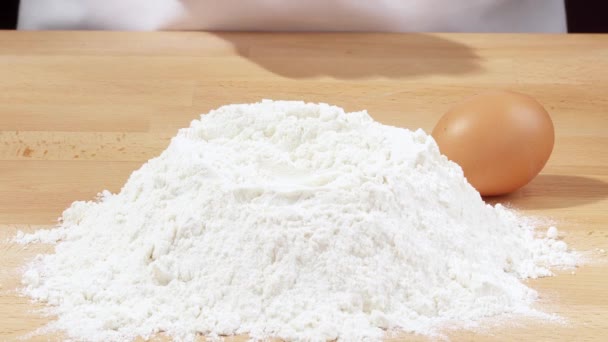 Breaking an egg into a heap of flour — Stock Video