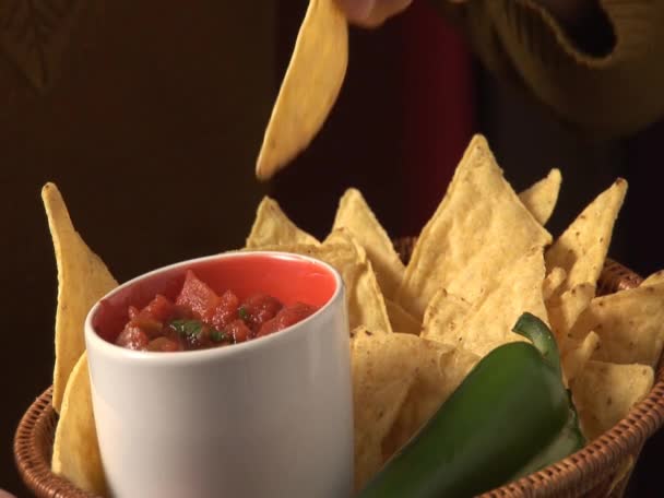 Dipping nachos in tomato salsa — Stock Video