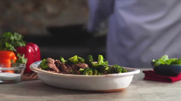 Beef with broccoli and chef on background — Stock Video