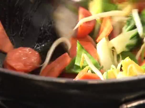 Wokning grönsaker i en wok — Stockvideo