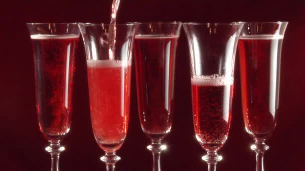 Gieten van rose wijn in glazen — Stockvideo