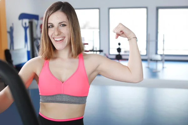 Young woman uses stationary bicycle trainer. — Stock Photo, Image