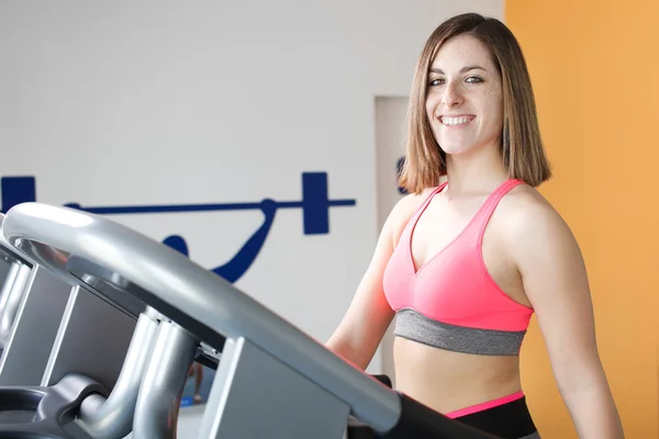 Chica joven haciendo ejercicio piernas en el gimnasio . —  Fotos de Stock