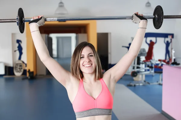 Stark kvinna tyngdlyftning på gymmet ser glad — Stockfoto