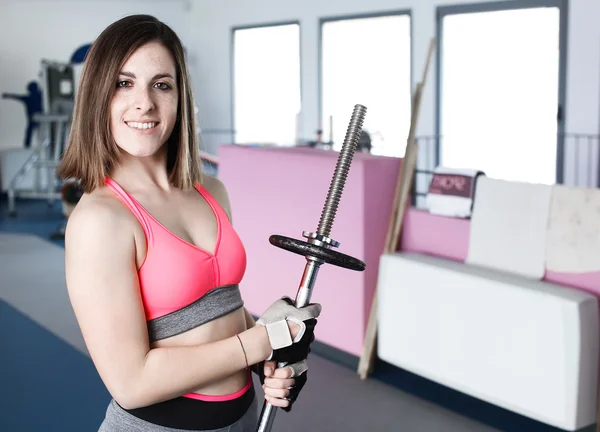 Stark kvinna tyngdlyftning på gymmet ser glad — Stockfoto