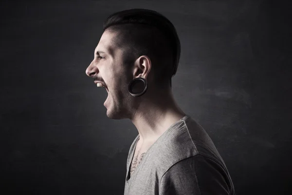 Portrait of angry man screaming isolated on gray background — Stockfoto