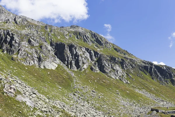 Beautiful green mountain in switzerland with grass and blue sky on summer end period — Stock Photo, Image