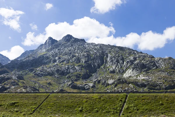 Bela montanha verde na Suíça com grama e céu azul no período final de verão — Fotografia de Stock