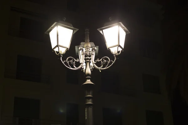 Stare lampy posty nad miastem w nocy — Zdjęcie stockowe