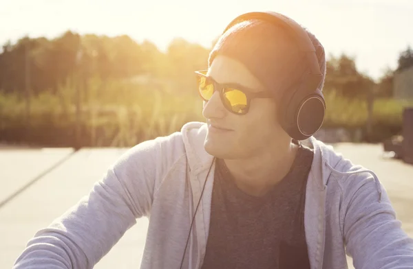 Зависимость от музыки. молодой человек слушает песни в наушниках — стоковое фото