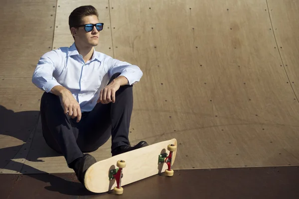 Yound kavkazské obchodní muž relaxační na skateboard . — Stock fotografie