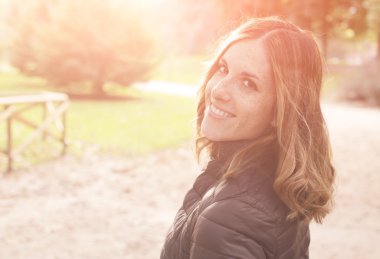 Günbatımı güneş arkasında çekici genç kadın ve güzel sonbahar renkleri