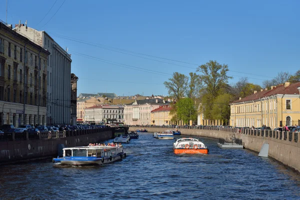 Łódka przyjemności z turystów nad brzegiem rzeki Moika, w mieście St. Petersbu — Zdjęcie stockowe