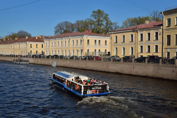 Łódka przyjemności z turystów nad brzegiem rzeki Moika, w mieście St. Petersbu — Zdjęcie stockowe