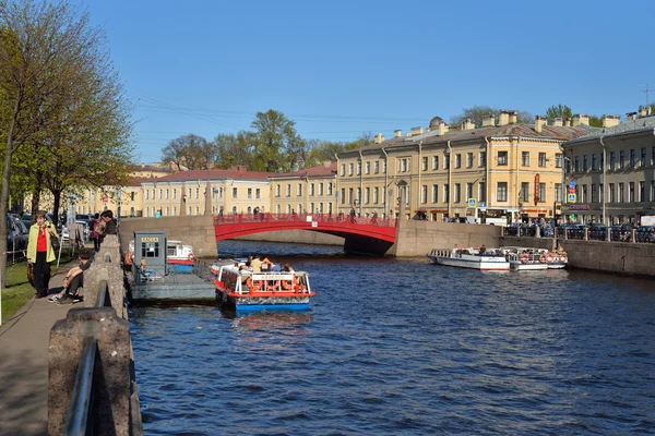 Łódka przyjemności z turystów nad brzegiem rzeki Moika, w mieście St. Petersbu — Zdjęcie stockowe