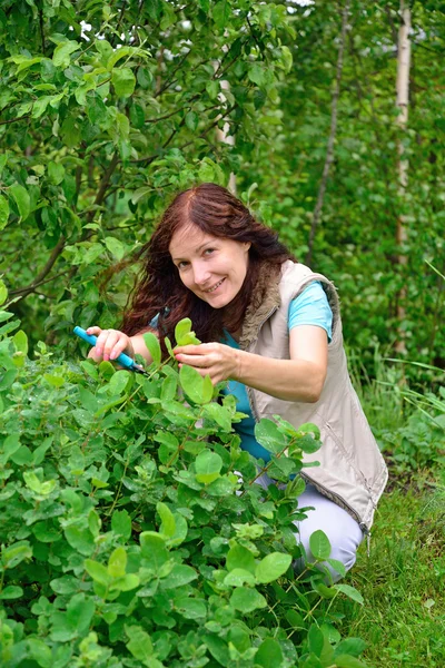 The girl with the green thumb sits on his haunches, smiling unde