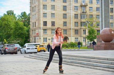 St. Petersburg 'daki Halk Kütüphanesi' nin önünde paten kayan kız öğrenci.