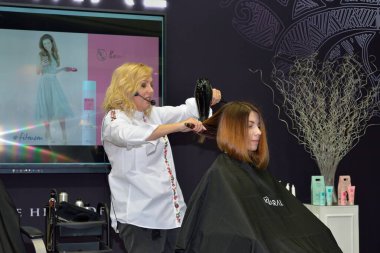 ST.PETERSBURG, RUSSIA - 23 Şubat 2018: Stilist saç stilisti bir müşteriyi, St. Petersburg 'daki güzellik festivali Nevskie Berega' da, Kaaral 'daki bir güzellik salonunda stil sahibi yaptı