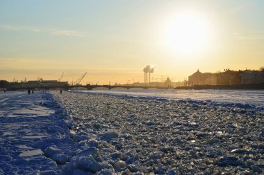 Neva nehri üzerindeki donmuş çimen yolu gün batımına Saint-Petersburg 'daki Annunciation köprüsüne gider.