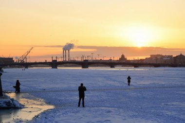 İnsanlar Saint-Petersburg 'da kış günbatımında Annunciation Köprüsü' nün fotoğraflarını çekiyor.
