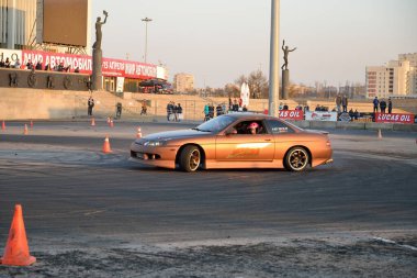 Altın yarış arabası JCC 'nin yanındaki pistte sürükleniyor.