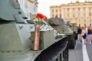 Ağır bir Sovyet tankının üzerindeki silah fişeğindeki kırmızı karanfiller.