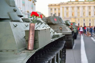 Ağır bir Sovyet tankının üzerindeki silah fişeğindeki kırmızı karanfiller.