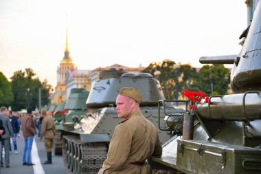 Mermi kovanında askerler ve kırmızı karanfiller ve bir kutu.