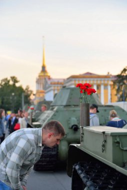 Bir adam Dvortsovaya squa 'da Sovyet orta tank T-34' ü inceliyor.