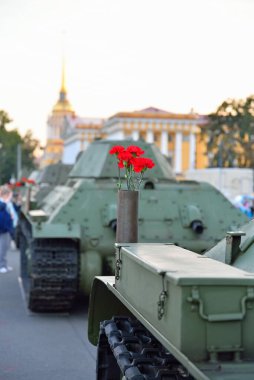 Orta boy Sovyet tankı T-34 'ün üzerindeki bir silah kartuşunda kırmızı çiçekler.