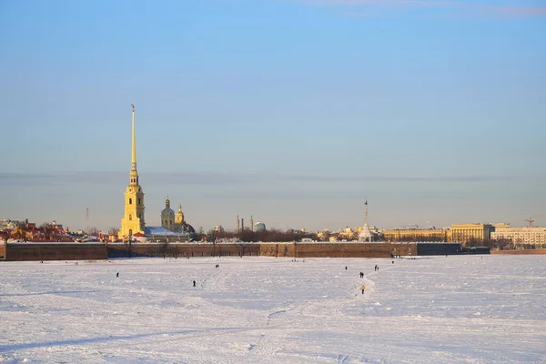 人々はピーターとポール要塞の前のネヴァ川の氷の上を歩くサンクトペテルブルクの晴れた日に — ストック写真