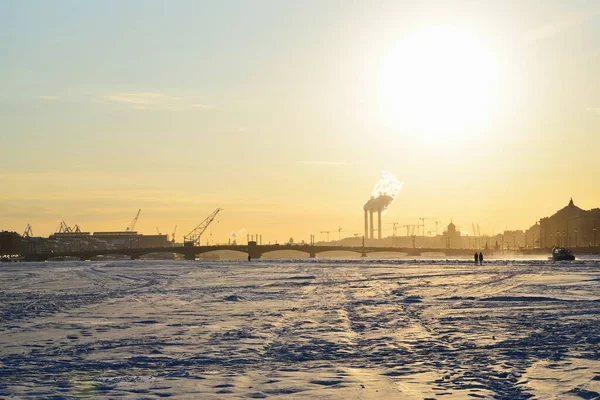 Saint-Petersburg 'da gün batımında Neva nehrinin buzundan Annunciation Köprüsü manzarası