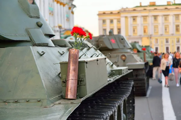 Ağır bir Sovyet tankının üzerindeki silah fişeğindeki kırmızı karanfiller.