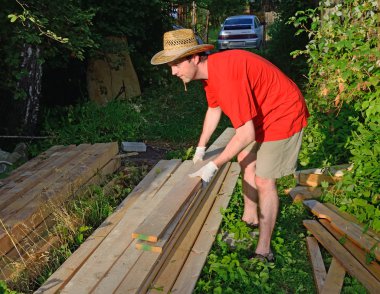 A young man in balomenou hat puts the Board in Stebel in the summer on a Sunny day in the village closeup