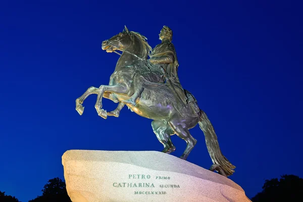 Monument to Peter 1, "the bronze horseman" in front of the building of Senate and Synod in St. Petersburg at night illuminated by beautiful lights against the dark blue sky closeup — Stock Photo, Image