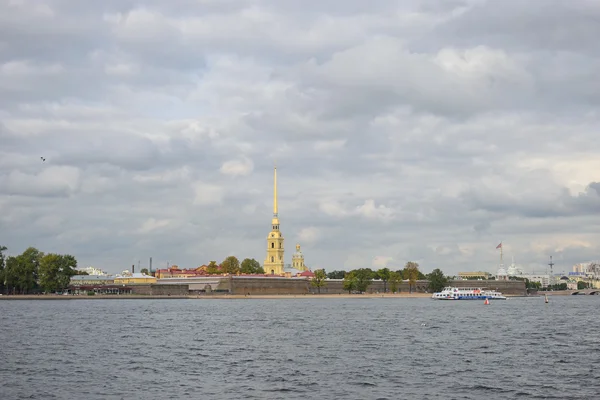 Panorama of the Peter and Paul fortress and a pleasure boat on receive under the beautiful gray Cumulus clouds — Stock Photo, Image