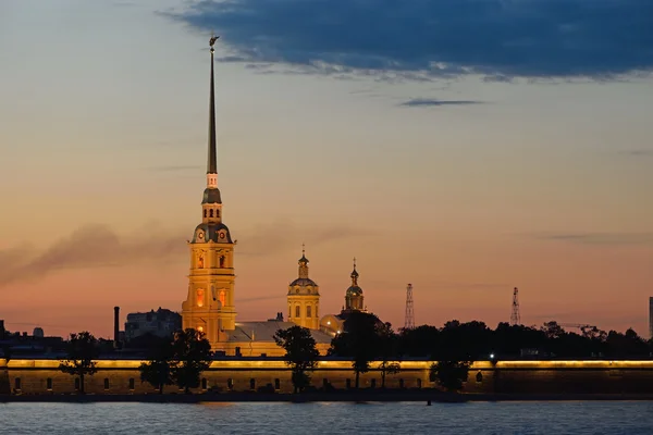Peter and Paul fortress illuminated at sunset, the reflection in — Stock Photo, Image