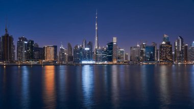  Dubai 'nin alacakaranlıktaki silüeti Business Bay bölgesindeki Dubai Kanalı' nın karşısından görülüyor..                              
