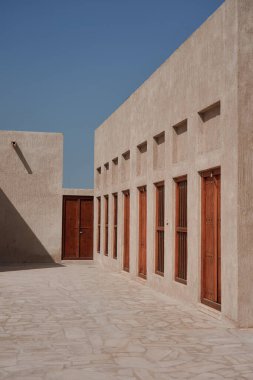Dubai 'deki Heritage Village, Birleşik Arap Emirlikleri' ndeki binalardan birinin dış duvarı ve ahşap kapıları ve pencereleri..                            