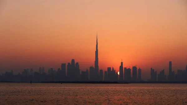 在夕阳西下形成的橙色天空映衬下的迪拜天际线轮廓 — 图库照片