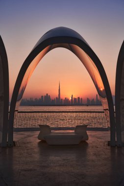  Gün batımında Dubai 'nin silueti kemer şeklinde oturma gölgesi ile çerçevelenmiş..                              