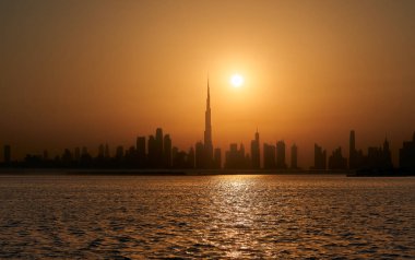 Dubai 'nin siluetinin silueti öğleden sonra güneşinin altın ışığına karşı.                               