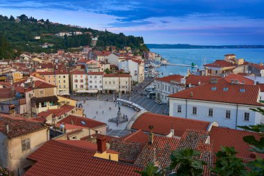  Piran 'ın Tartini Merkez Meydanı ve kırmızı çatı binaları. Alacakaranlıkta yukarıdan bak.                                                             