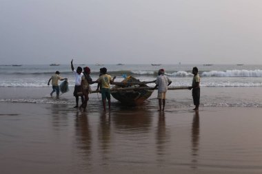 Hindistan sahillerinde balıkçı tekneleri olan balıkçılar. 